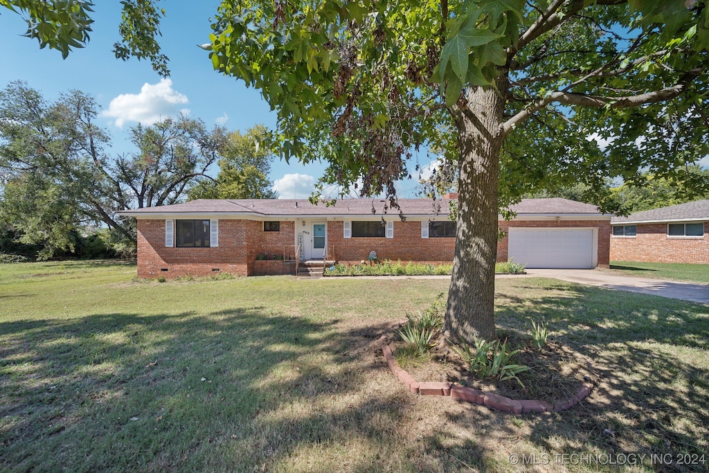 ranch-style home featuring a front lawn and a garage