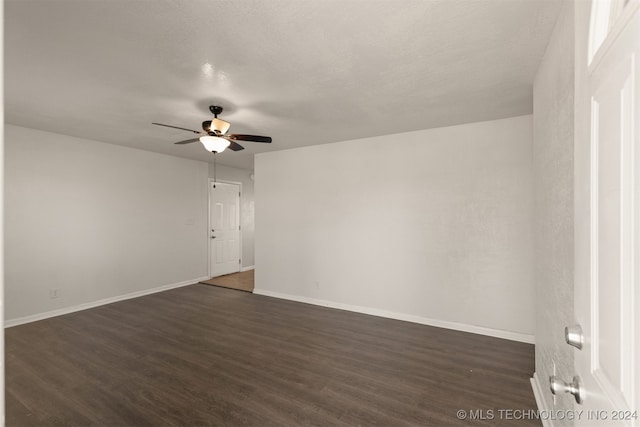 spare room featuring a textured ceiling, ceiling fan, and dark wood-type flooring