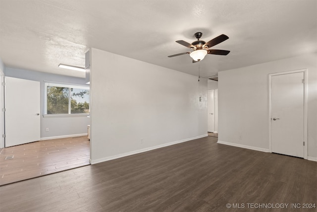 spare room with ceiling fan, dark hardwood / wood-style floors, and a textured ceiling