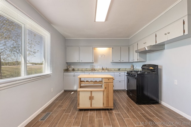 kitchen with ornamental molding, dark hardwood / wood-style floors, sink, and black gas range