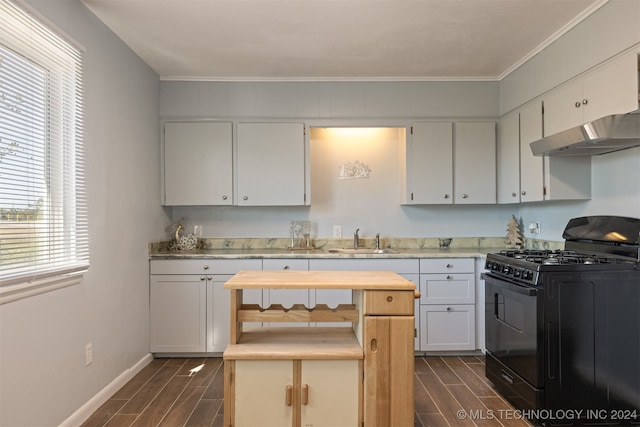 kitchen with ornamental molding, sink, dark wood-type flooring, white cabinetry, and gas stove