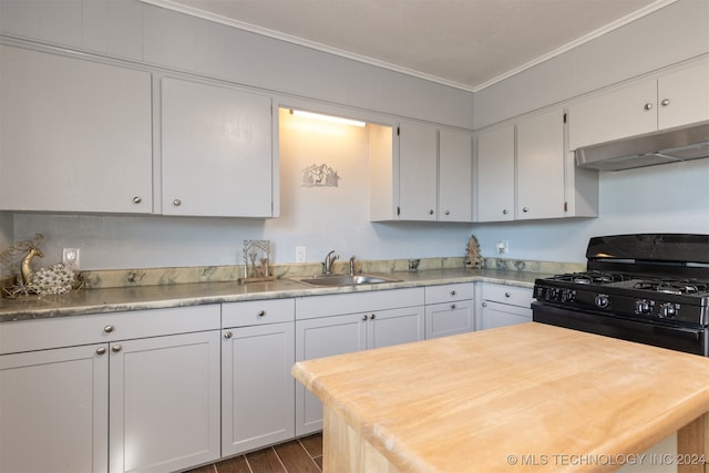 kitchen with ornamental molding, white cabinets, black range with gas stovetop, and sink