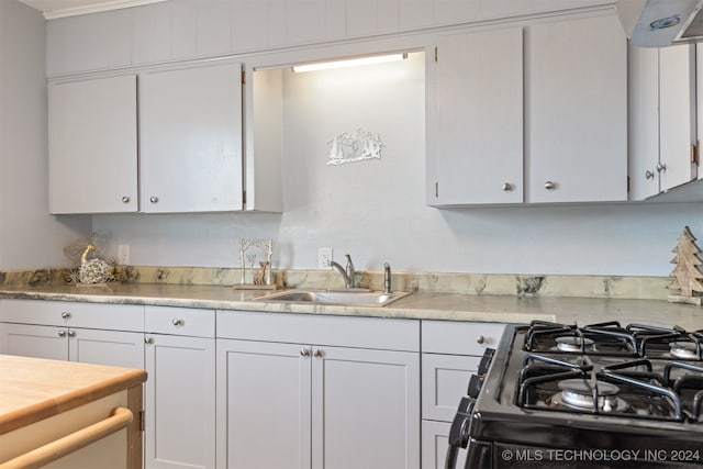 kitchen featuring white cabinets, stainless steel range with gas cooktop, and sink