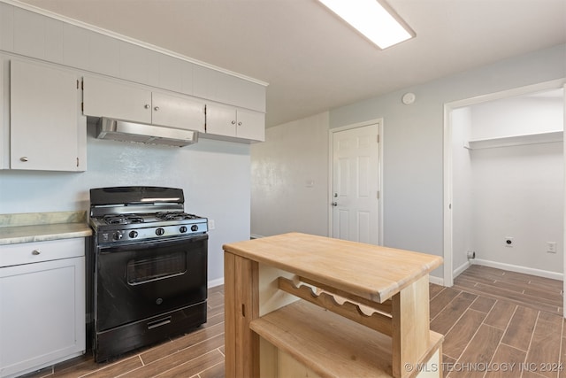 kitchen with white cabinets, dark hardwood / wood-style floors, black gas range oven, and range hood