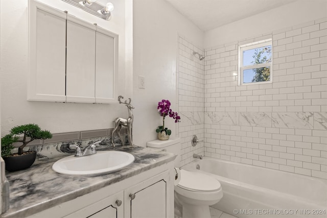 full bathroom with tiled shower / bath, vanity, and toilet