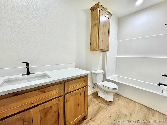 full bathroom featuring vanity, hardwood / wood-style floors, shower / bathing tub combination, and toilet