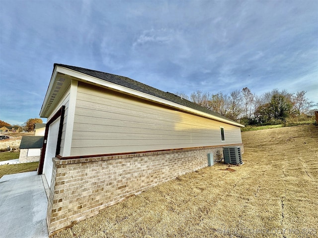 view of home's exterior with cooling unit and a garage