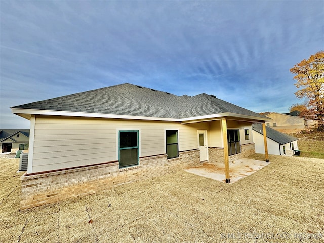 back of house featuring a lawn and a patio