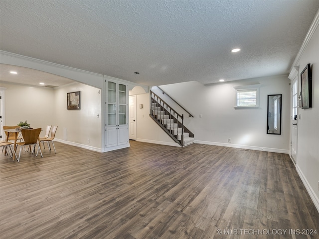 living room featuring ornamental molding, a textured ceiling, and dark hardwood / wood-style floors