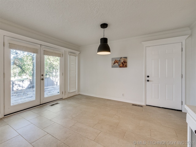 unfurnished dining area featuring french doors, a textured ceiling, and ornamental molding