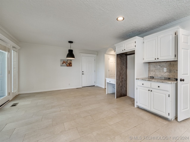 kitchen featuring decorative backsplash, light stone counters, white cabinets, decorative light fixtures, and ornamental molding