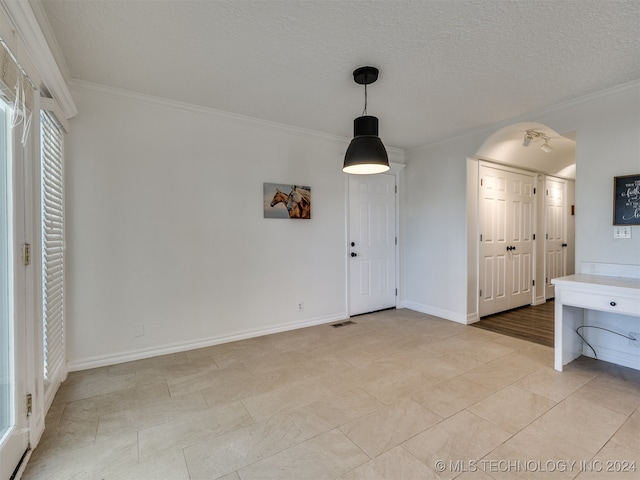 interior space featuring ornamental molding and a textured ceiling