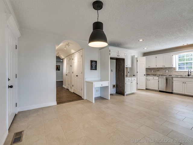 kitchen featuring white cabinets, crown molding, and stainless steel dishwasher