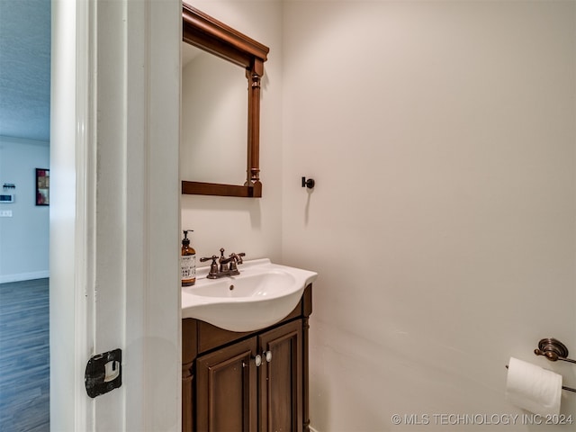 bathroom with vanity, a textured ceiling, and hardwood / wood-style flooring