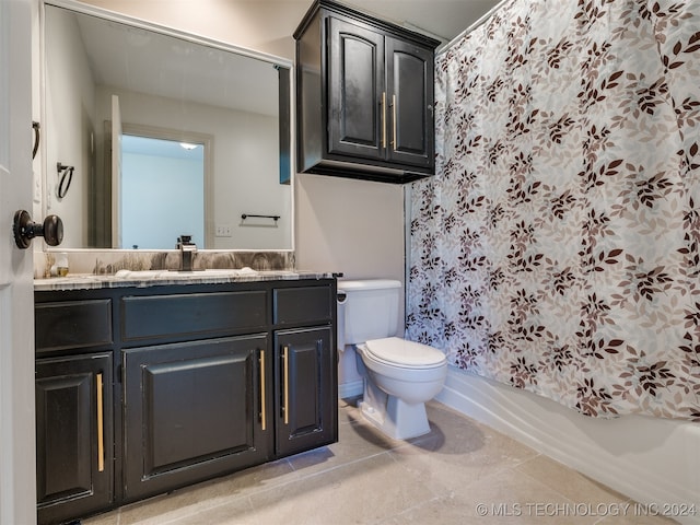 full bathroom featuring vanity, shower / bath combo with shower curtain, toilet, and tile patterned flooring