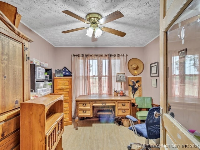 home office with ceiling fan, a textured ceiling, light wood-type flooring, and crown molding