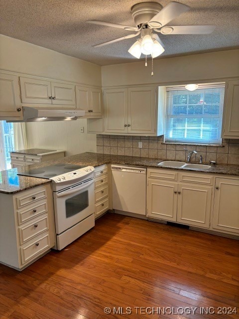 kitchen with a wealth of natural light, sink, white cabinetry, light hardwood / wood-style flooring, and white appliances