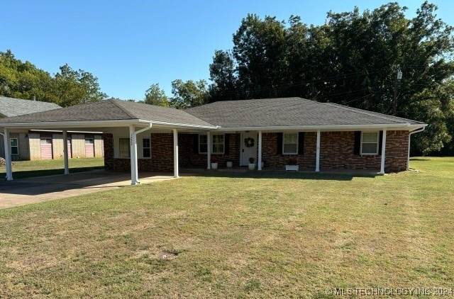 ranch-style house featuring a front yard and a carport