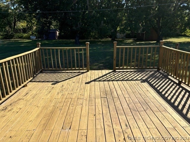 deck featuring a storage shed and a yard