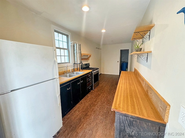 kitchen with white refrigerator, gas range, dark hardwood / wood-style flooring, and sink