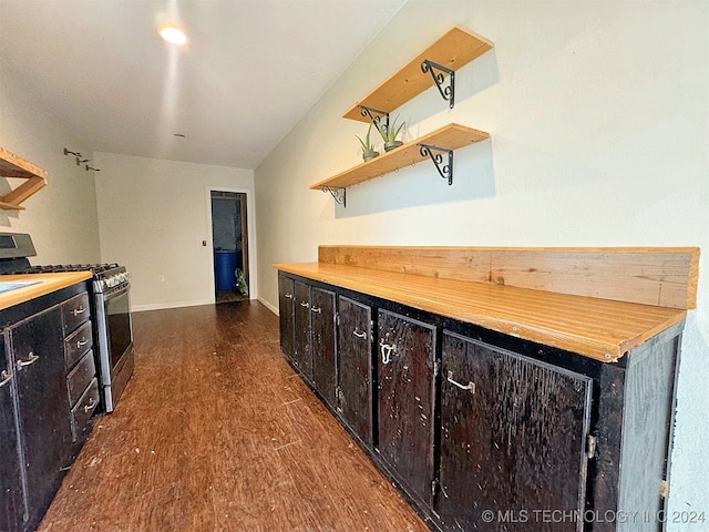 kitchen with butcher block counters, dark brown cabinets, gas range, and dark hardwood / wood-style flooring