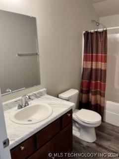 full bathroom featuring shower / bath combination with curtain, toilet, and vanity