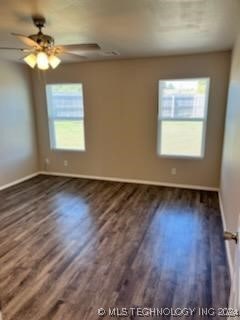 spare room with ceiling fan and dark wood-type flooring