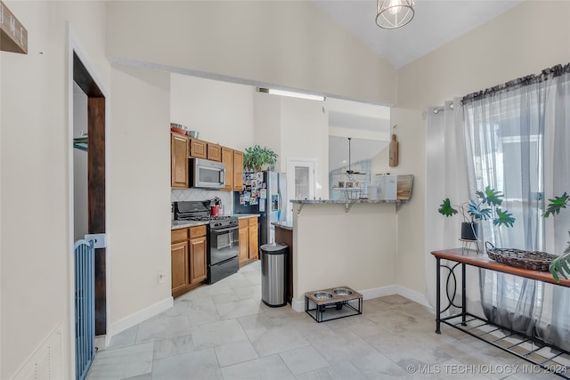 kitchen with decorative backsplash, kitchen peninsula, pendant lighting, and stainless steel appliances