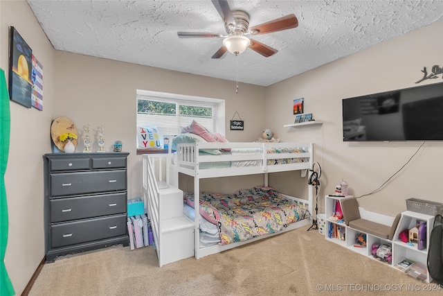 carpeted bedroom with ceiling fan and a textured ceiling