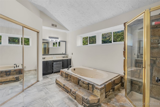 bathroom with a textured ceiling, separate shower and tub, vanity, and vaulted ceiling