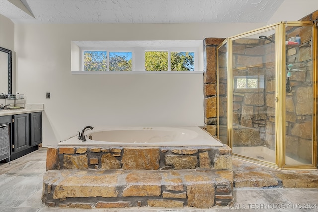 bathroom with vanity, plus walk in shower, and a textured ceiling