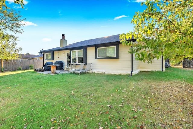 back of property with a lawn and a patio