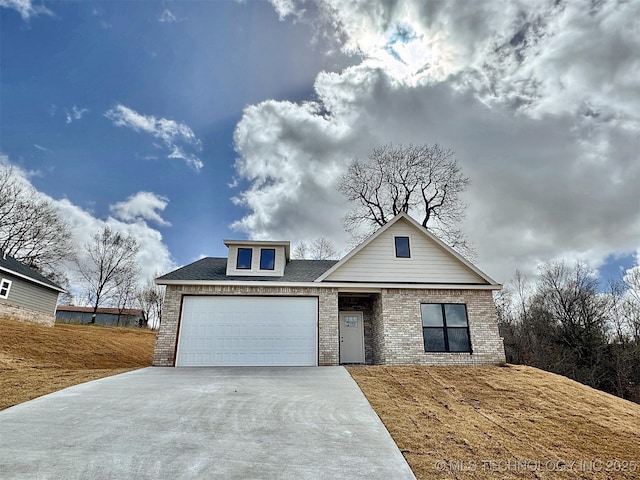 view of front of property featuring a garage, concrete driveway, and brick siding