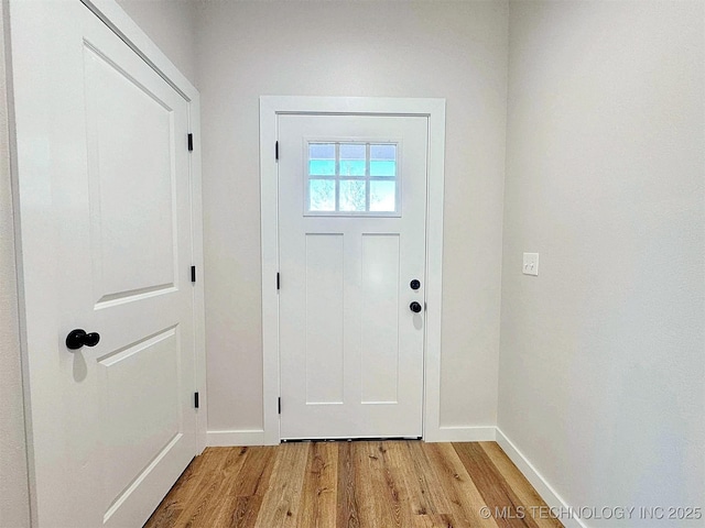 doorway to outside featuring light wood-style flooring and baseboards