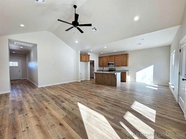 unfurnished living room featuring light wood-style floors, visible vents, vaulted ceiling, and recessed lighting