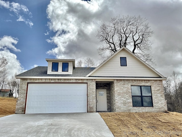 view of front of house with concrete driveway, brick siding, and an attached garage