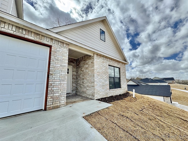 exterior space with brick siding and an attached garage