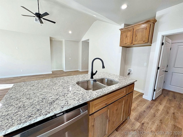 kitchen with dishwasher, a sink, light wood-style flooring, and lofted ceiling