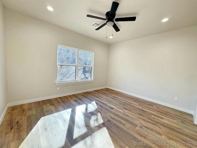 spare room with baseboards, visible vents, wood finished floors, and recessed lighting