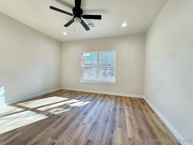 empty room with recessed lighting, visible vents, ceiling fan, wood finished floors, and baseboards