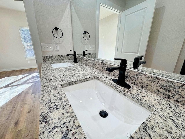 856 E Harlan Dr, Tahlequah, OK 74464 - bathroom with wood finished floors, double vanity, and baseboards