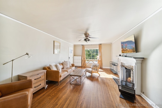 living room with ceiling fan, ornamental molding, and dark hardwood / wood-style flooring