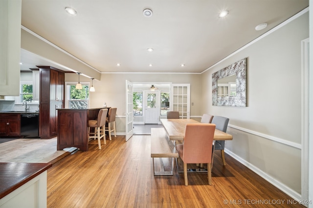 dining space featuring crown molding, light hardwood / wood-style floors, and french doors