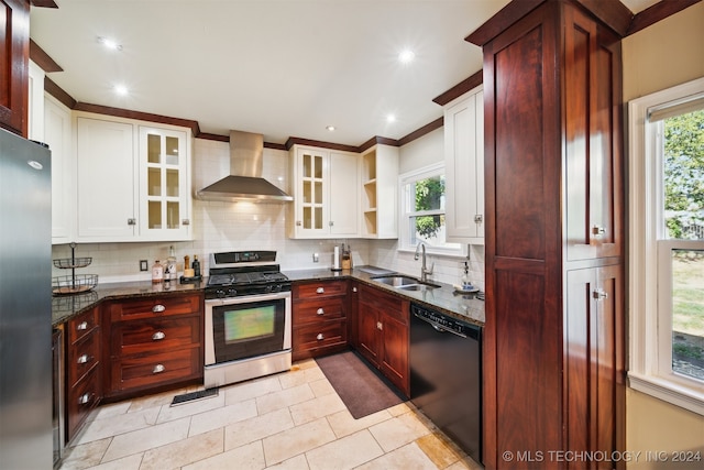 kitchen with wall chimney exhaust hood, white cabinets, appliances with stainless steel finishes, and plenty of natural light