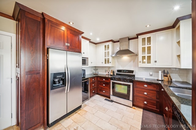 kitchen with appliances with stainless steel finishes, dark stone countertops, backsplash, sink, and wall chimney range hood