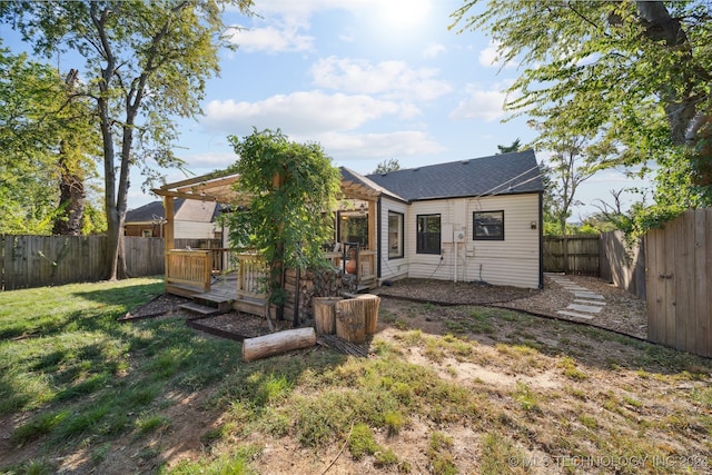 rear view of house with a lawn and a deck