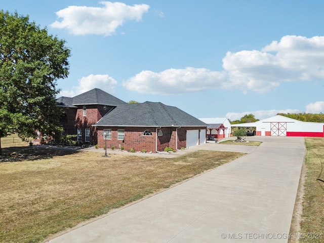 3691 E 390th Rd, Oologah, OK 74053 - view of front of property featuring concrete driveway, a front lawn, an outdoor structure, brick siding, and a garage