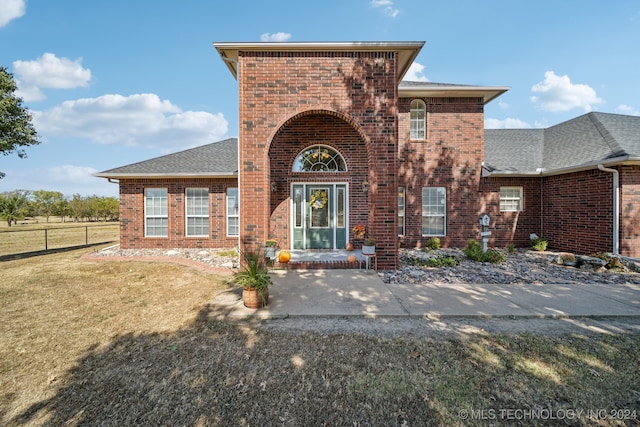 view of front facade with a front yard and a patio