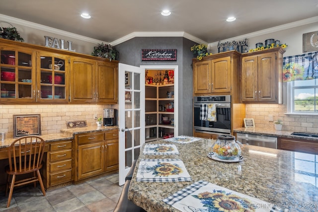 kitchen featuring ornamental molding, stainless steel appliances, light stone counters, and backsplash