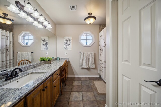 3691 E 390th Rd, Oologah, OK 74053 - bathroom featuring plenty of natural light, baseboards, vanity, and stone finish floors